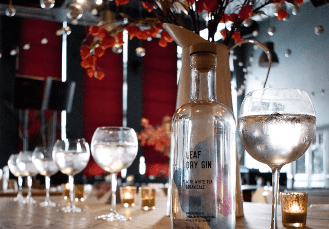 LEAF Dry Gin with multiple glasses in a bar