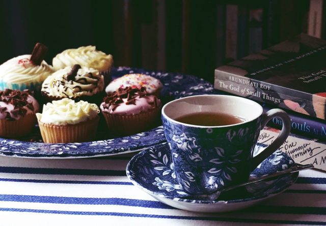 A traditional chine tea set with tea and cupcakes