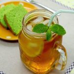 Lemon Iced Tea in a glass container and green cake in the background
