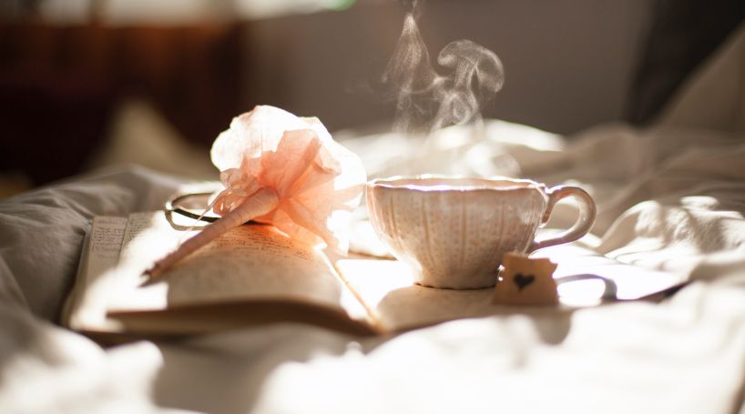 steaming tea with rose on book
