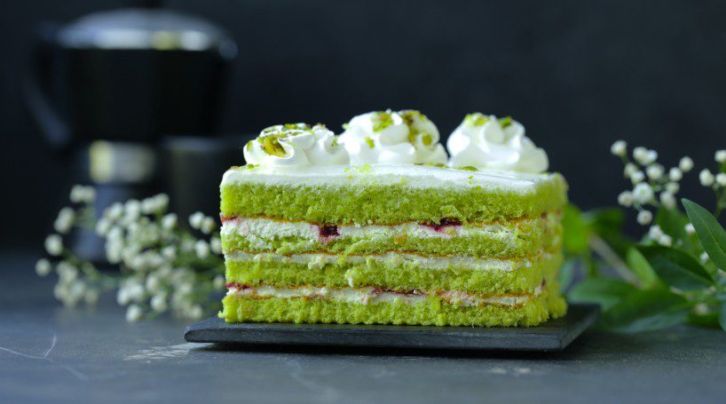 layered green matcha cake with whipped cream
