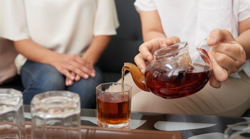 Person with tea pot pouring english tea